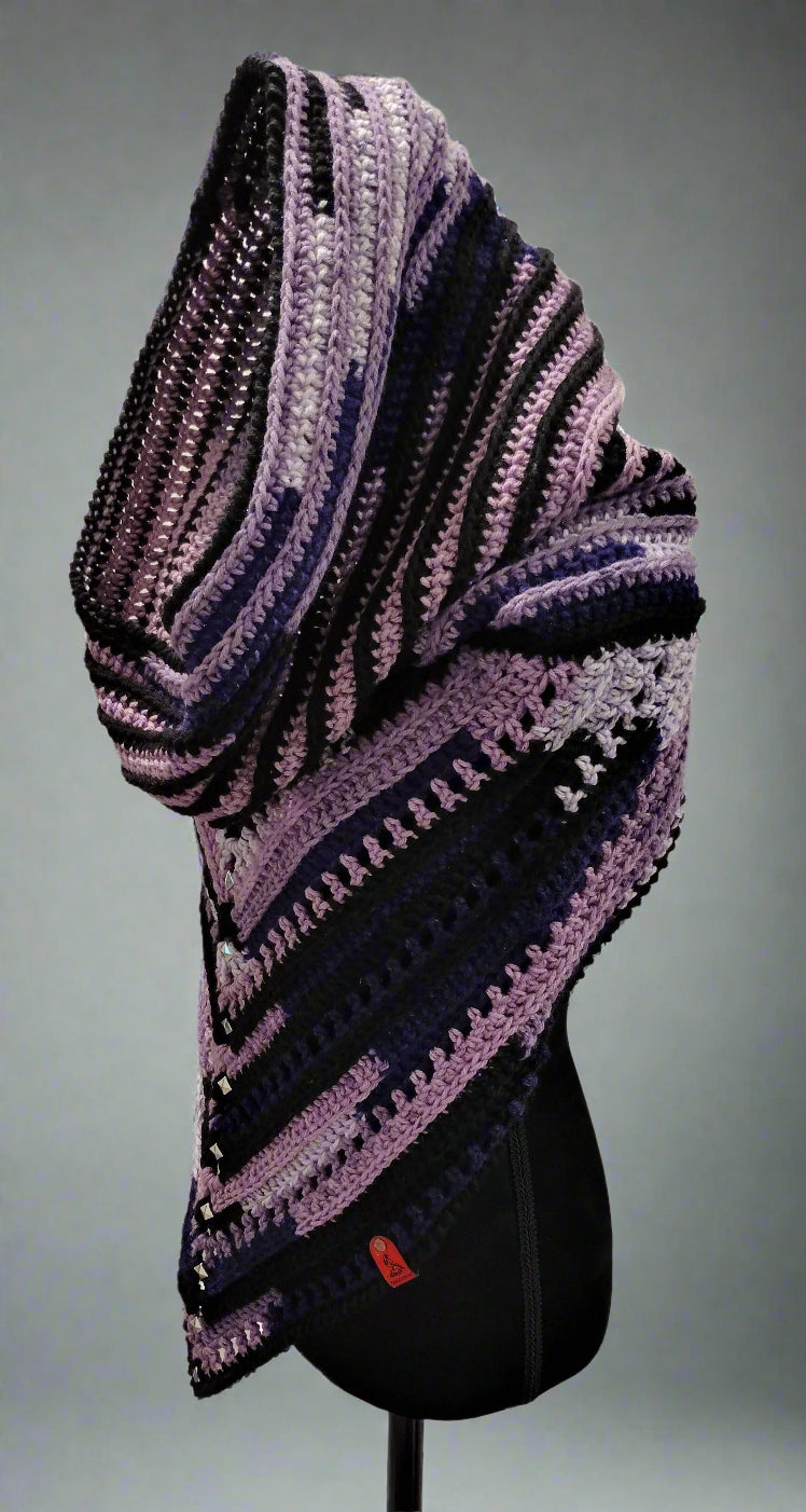 Purple and black striped shawl on a mannequin against a white wall